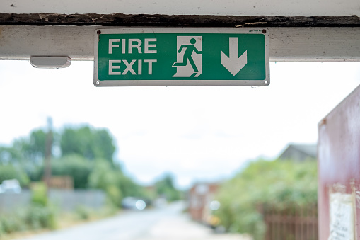 The sign is one of a number of Fire Exit signs used as a Health and Safety procedure during a business or commercial fire or fire drill.