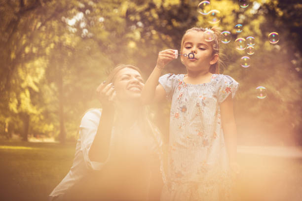 istock Mother and daughter have fun with water bubbles. 1003438392