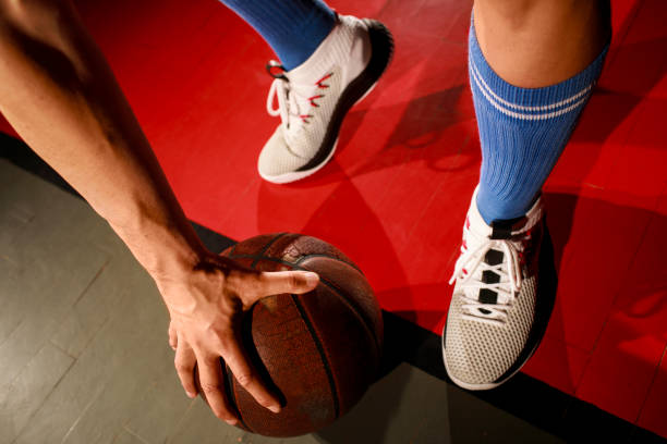 istock Basketball player holding basketball with one hand. 1003440460