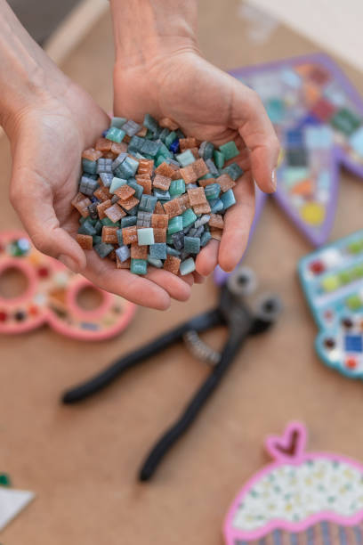 local de trabalho do mestre mosaico: mãos de mulheres com detalhes de mosaico no processo de fazer um mosaico - mosaic human hand craft artist - fotografias e filmes do acervo