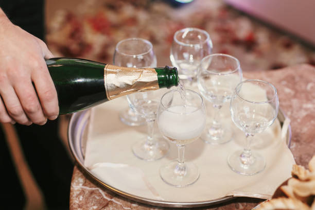 istock waiter pouring champagne into empty glases at wedding reception. holiday celebrations. luxury catering in restaurant 1003466320
