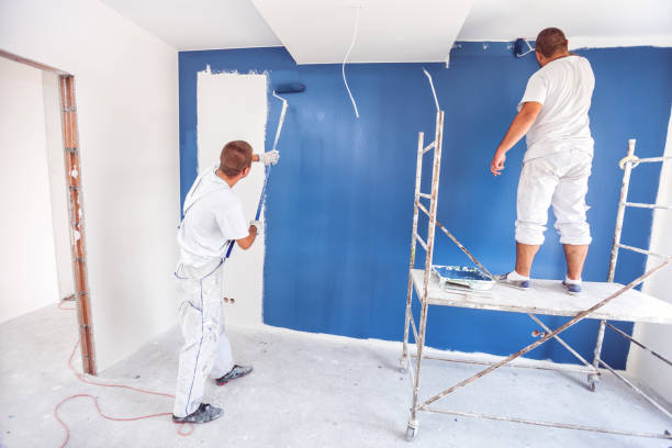 istock House painters beginning to paint a large blue wall 1003471946