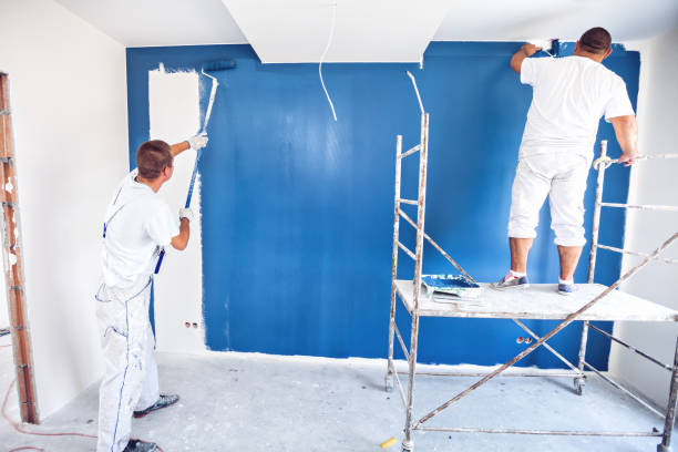 istock House painters beginning to paint a large blue wall 1003471984