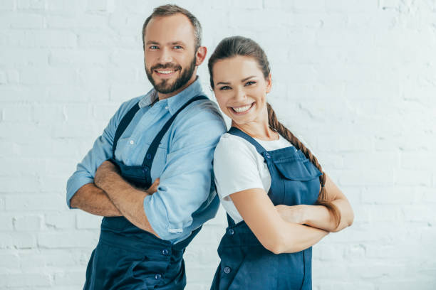 istock smiling confident workers in uniform posing with crossed arms 1003473062