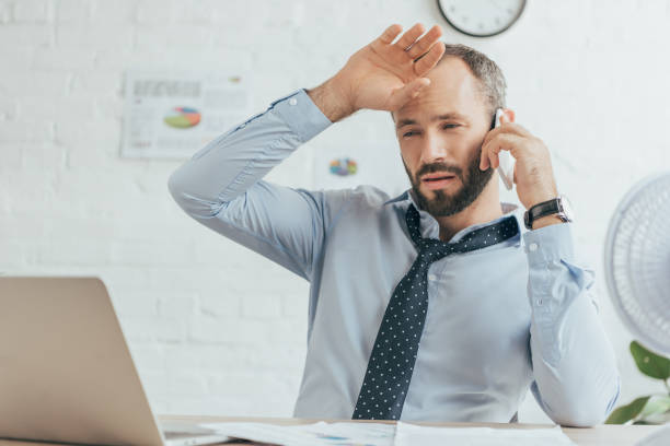 istock exhausted sweaty businessman talking on smartphone and working in hot office 1003474480
