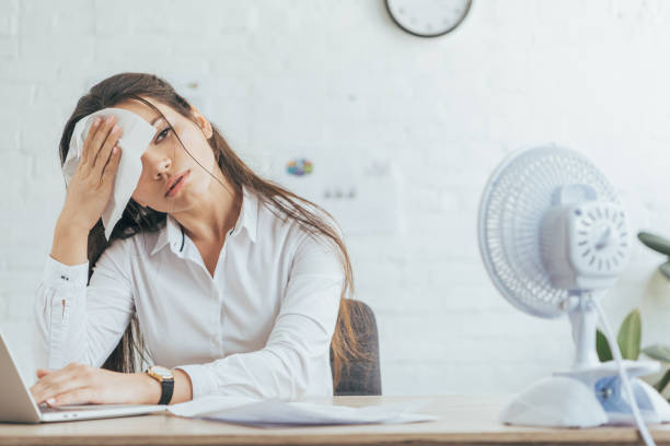 empresária suada, trabalhando no escritório com ventilador elétrico - office fan - fotografias e filmes do acervo