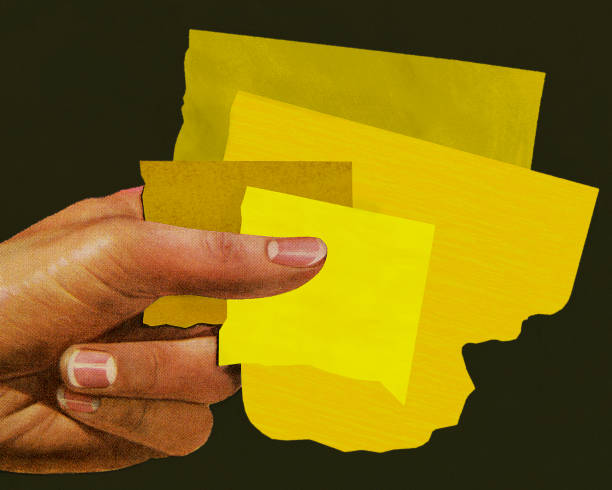 istock Hand Holding Pieces of Yellow Paper 1003484620