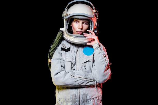 attractive female astronaut in spacesuit and helmet isolated on black - spacewoman imagens e fotografias de stock