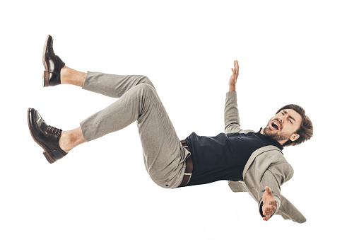shouting young businessman in suit falling isolated on white