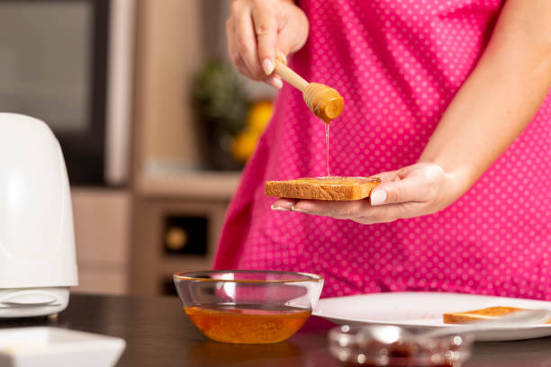 Woman making honey and butter sandwich