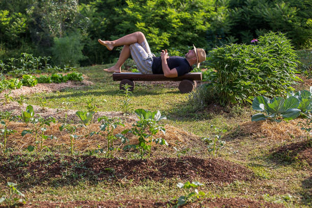 istock Young man with the hat rests in a Home Grown Vegetable Garden 1003515020