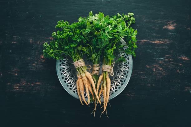 istock Fresh green parsley. Root parsley. On a wooden background. Top view. Copy space. 1003515098