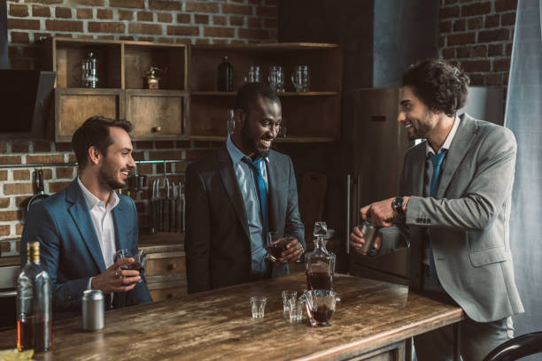istock three young multiethnic businessmen drinking alcoholic beverages and partying together 1003529472