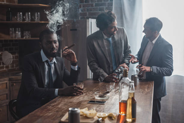 istock three multiethnic men in suits drinking alcohol beverages and smoking cigars together 1003529568