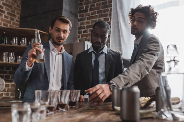 istock young multiethnic friends in suits drinking alcohol beverages together 1003529762