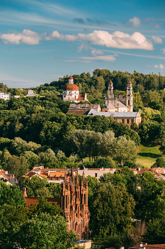 Vilna, Lituania. Vista de la iglesia católica de Santa Ana, Iglesia de la ascensión e Iglesia del sagrado corazón de Jesús entre un follaje verde en la ciudad vieja en día de verano. photo
