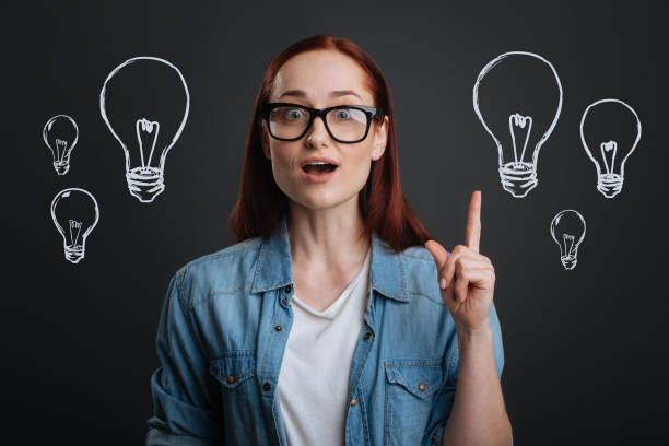 istock Clever designer pointing her finger up while getting a brilliant idea 1003539652