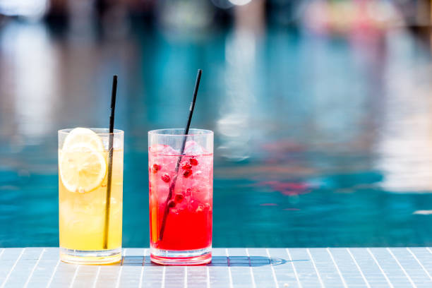 수영장가에서 맛 있는 붉은 색과 오렌지색 칵테일 잔의 근접 촬영 - drink swimming pool cocktail poolside 뉴스 사진 이미지