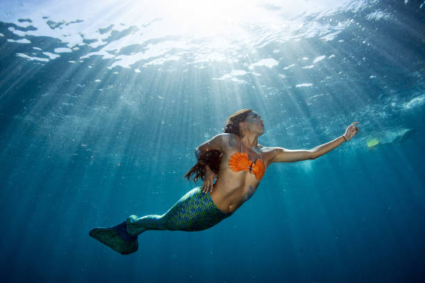 istock Mermaid swimming underwater in the deep blue sea 1003542852