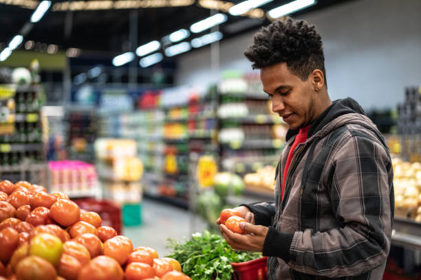istock Customer Choosing Tomatoes at Supermarket 1003545414