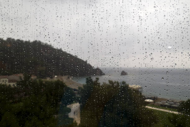 Rainy view on the beach through the window