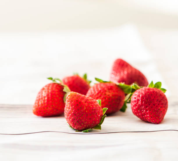 istock Fresh strawberries close up on wooden background 1003547676