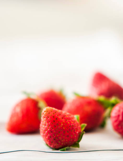 istock Fresh strawberries close up on wooden background 1003547700