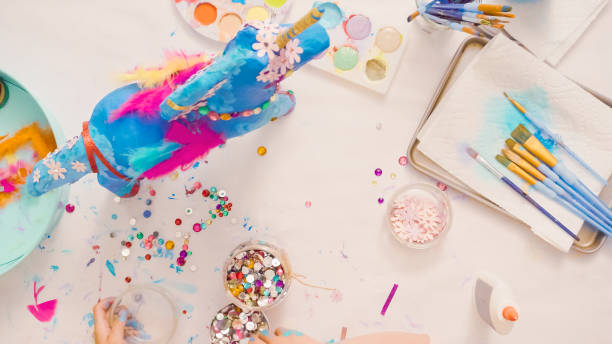istock Decorating painted paper mache unicorn 1003550844
