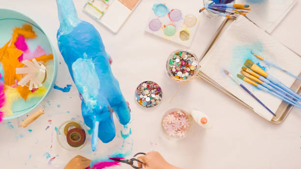 istock Decorating painted paper mache unicorn 1003550880