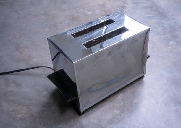 Classic vintage chrome toaster on concrete floor background.