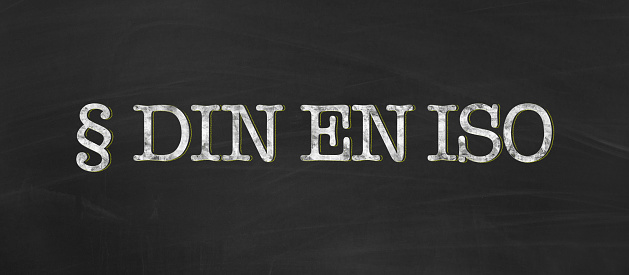 DIN EN ISO abbreviation for german industry standard, european standard and international organization for standardization written with chalk on blackboard as banner