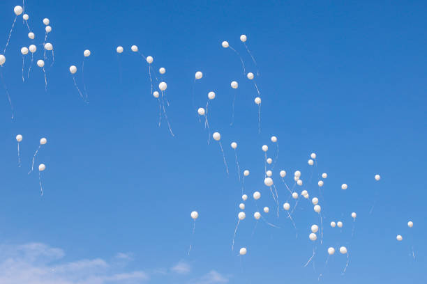 istock White balloons flying in the sky. 1003557738