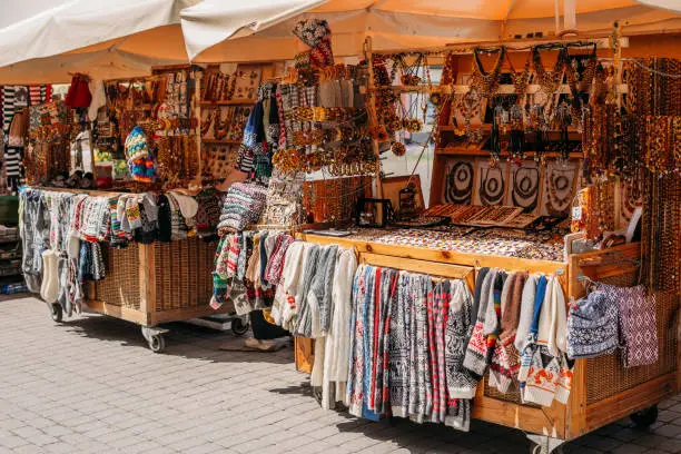 Photo of Riga, Latvia. Street Market In Livu Square. Trading Houses With Sale Of Gifts, Sweets And Souvenirs Made From Wood And Amber