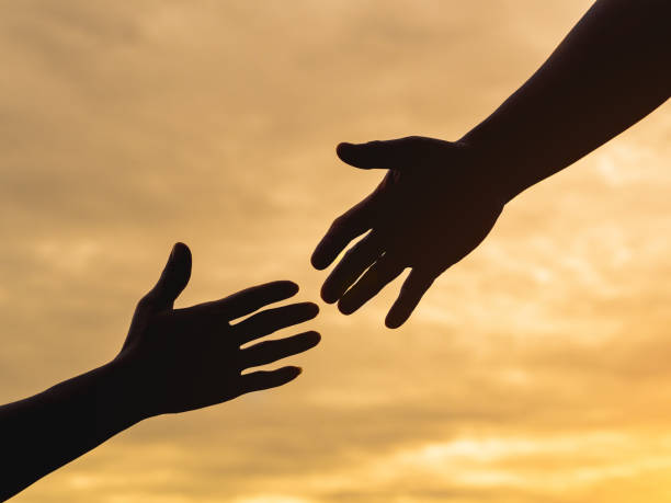 istock Closeup helping hands on the sunset sky background. Rescue & Help Concept 1003566022