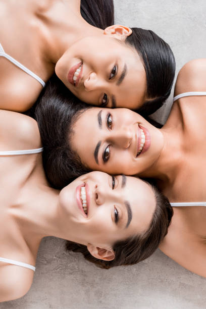 istock top view of attractive smiling multicultural girls looking at camera 1003566356