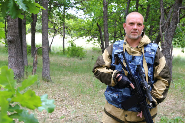 istock On the hunt. A military man hunter is standing with a firearm in the forest. 1003568562