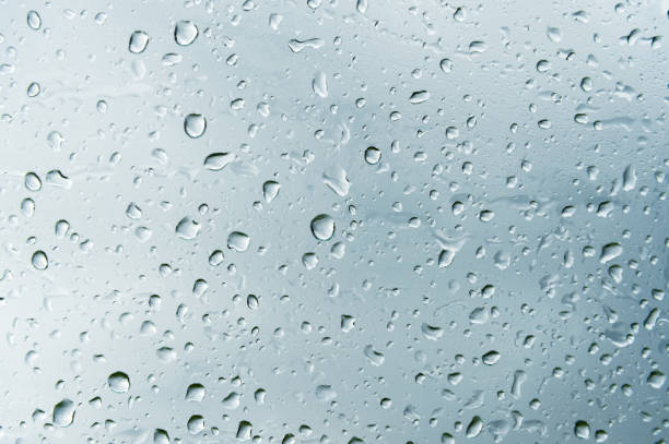 istock Textured background of window panes with a cloudy background. Natural pattern from a drop of rain on a cloudy background 1003569054