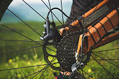 Close-up view of rear wheel cassette from mountain bike on the landscape and green grass