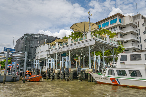 Bangkok, Thailand - May 02 2018:  The Chao Phraya river runs through the centre of Thailand’s capital city, Bangkok.  The express boat service is part of the cities major transport network, with multiple Piers along the route.  Here we see the Marine Department Pier, with numerous commuters waiting.