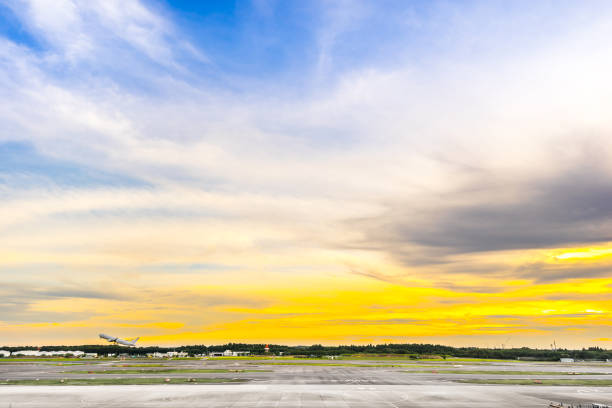istock panoramic view of apron and airplane on runway under dramatic sunset & cloud sky 1003575160