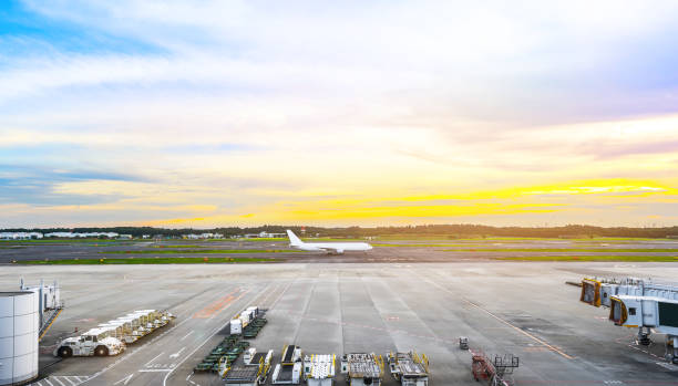 istock panoramic view of apron and airplane on runway under dramatic sunset & cloud sky 1003575542
