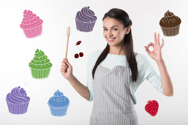 istock Happy cook holding a wooden spoon and looking confident 1003578776