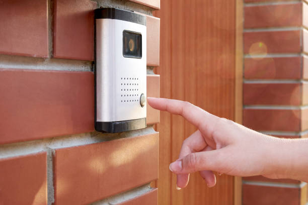 la mano femenina pulsa un timbre botón con cámara e intercom - pushing women wall people fotografías e imágenes de stock