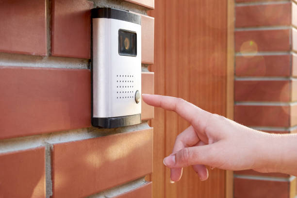 The female hand presses a button doorbell with camera and intercom The female hand presses a button doorbell with camera and intercom doorbell photos stock pictures, royalty-free photos & images