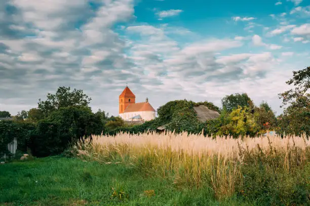 Photo of Mir, Belarus. Landscape Of Village Houses And Saint Nicolas Roman Catholic Church In Mir, Belarus. Famous Landmark
