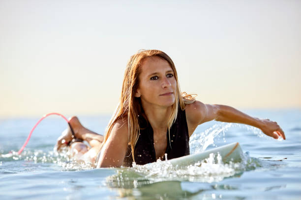 istock Beautiful woman looking away while surfing in sea 1003589128
