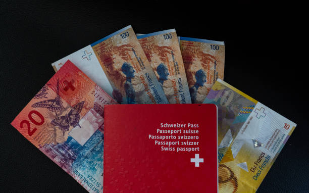argent et passeport suisse gros plan sur la citoyenneté suisse fond noir - switzerland swiss currency chf euro symbol photos et images de collection