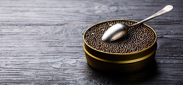 Caviar negro en lata y la cuchara de plata photo