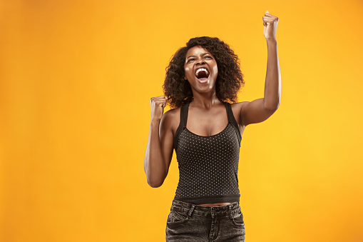 I won. Winning success happy woman celebrating being a winner. Dynamic image of caucasian female model on yellow studio background. Victory, delight concept. Human facial emotions concept. Trendy colors