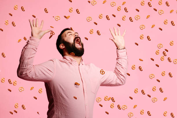 Attack of the pretzels Man trying to eat flying pretzels i want you stock pictures, royalty-free photos & images